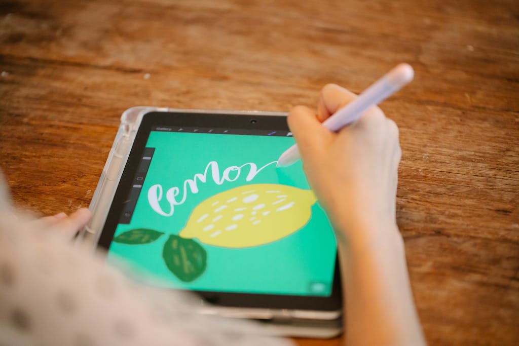 Artist drawing a lemon illustration on a tablet using a stylus, showcasing digital creativity.