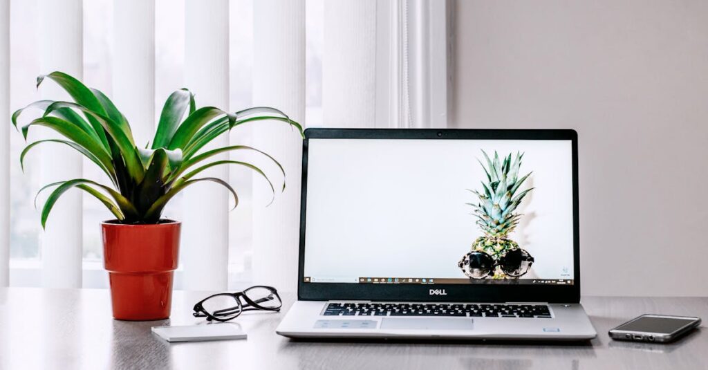 A stylish workspace featuring a laptop, plant, and smartphone on a desk.